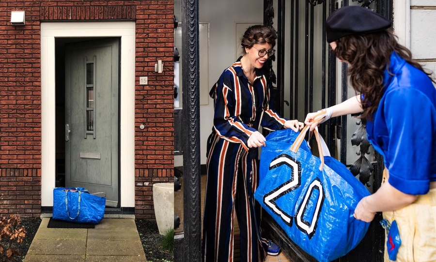 Two people exchanging a clothing loop bag at the front door.