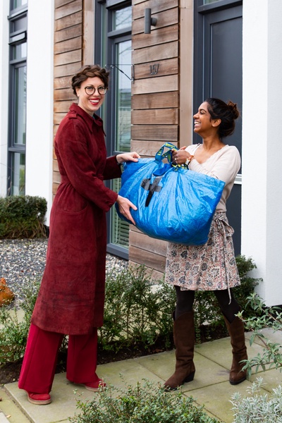 Nichon giving a large bag of clothes to another woman